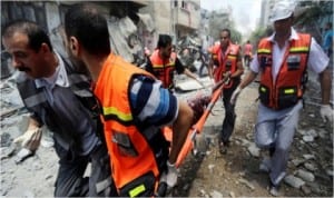 Palestinian medics carry a man injured in Gaza City's Shijaiyah neighborhood that came under fire as Israel widened its ground offensive against Hamas in the northern Gaza Strip, yesterday. Tens of people were killed in Shijaiyah and many more bodies were believed buried under the rubble of homes, health officials said. They are the latest casualties in a nearly two-week conflict that has killed some 380 Palestinians and seven Israelis. (AP Photo/Hatem Moussa) 