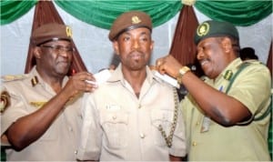 L-R: Comptroller, Nigeria Immigration Service, Rivers Command, Mr Mike Longe (left) and Controller of Prisons, Rivers Command, Mr Patrick Ondoma (right) decorating Mr Vincent Ekoko with his new rank,  during decoration of newly promoted officers of Immigration Service in Port Harcourt, last Friday 