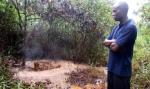 A youth leader in Kalaba community, Mr Samuel Oburo, at the oil spill site within an oil field in Kalaba community, Yenagoa Local Government Area of Bayelsa State, recently.