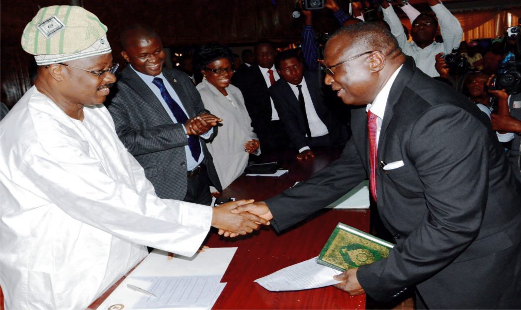 Gov. Abiola Ajimobi (left) of Oyo State Congratulating Acting Chief Judge of Oyo State, Mr Mukhtair Abimbola, during his swearing-in in Ibadan recently. Photo: NAN