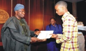 President Goodluck Jonathan presenting letter of employment to Mr Raymond Enoh, a family member of victims of 2014 Nigeria Immigration recruitment tragedy, in Abuja.  With them are the Chairman, Federal Civil Service Commission, Mrs Joan Ayo