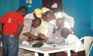 A House of Assembly candidate of Peoples Democratic Party  in Mushin Local Government Area, Mr Lekan Fijabi with others (left), testing the workings of Card Readers in Onigbongbo Ward, Ikeja LGA, Lagos, recently.