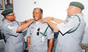 Assistant Comptroller General, Nigeria Custom Service, Port Harcourt, Mohammed Ahmed (right), assisted by Comptroller Babani Abdullahi in decorating Deputy Comptroller Oche Alex in Port Harcourt Oon Thursday.