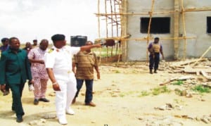 Commanding Officer,  Navy Out-post, Onitsha, Navy Capt. Mike Oamen, conducting  newsmen  round the nearly completed new administrative building within the new Naval Base complex, recently.                       Photo: NAN