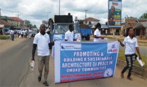 Youth of Omoku community in Rivers State with a banner during a peace rally in the community, yesterday