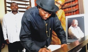 President Goodluck Jonathan signing the condolence register, during his visit to the late Senior Special Assistant to the President on Research and Documentation, Mr Oronto Douglas' family in Abuja, yesterday. Behind the President is the Managing Director, News Agency of Nigeria (NAN), Mr Ima Niboro.