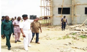 Commanding officer, Navy out-post, Onitsha, Navy Capt. Mike Oamen, conducting newsmen round the nearly completed new administrative building within the new Navy Base Complex, recently.