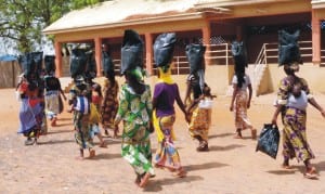 Some internally displaced persons carrying their foodstuffs shortly after  a special prayer to mark the anniversary of the abduction of Chibok Girls  held at St. Theresa Catholic Cathedral  Church in Jimeta,Yola in Adamawa State last Wednesday.