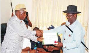 INEC  National Commissioner, Dr Ishmael  Igbani (left), presenting Certificate of Return  to  Senator  Representing Bayelsa West Senatorial Zone,  Mr Foster Ogular, at INEC office in Bayelsa State, last Friday.