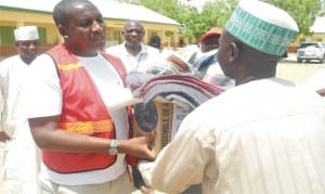 Head of Training and Resource Mobilisation, Malam Auwal Mohammed (left), presenting relief materials to Malam Alkali Azir, one of the Internally Displaced Persons (IDPs), at the distribution of relief materials donated to IDPs by the Red Cross Society of Nigeria and  United Nations High Commissioner for Refugees  in  Gombe, last Tuesday.