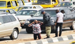 A man being punished by a  law enforcement  officer for not using Pedestrian Bridge in Ikeja, Lagos, yesterday