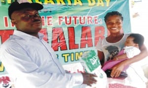 Director, Africare Malaria Programme, Dr Patrick Adah (left), presenting insecticide-treated mosquito nets to a nursing mother, during last 2015 World Malaria Day celebration at Upenekang, Ibeno Local Government Area in Akwa Ibom State recently.