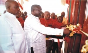 The chairman of the occasion, Mr. Tamuno Ajubo Atamuno cutting the tape to declare the speed boat house open at Okrika  while Rev Iyolobia Tamunokonbia and members of the association watch, recently.                                       Photo: NAN