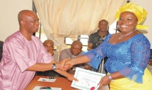 The Resident Electoral Commissioner for Bayelsa State, Mr Baritor Kpagih (left), presenting certificate-of-return to Princess Ingo Iwari (pdp), member-elect representing Ogbia Constuency 2 in Bayelsa House of Assembly, at the inec office in Yenagoa last Tuesday. Photo: NAN