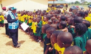 Co-ordinator, Frsc Special Marshals and Partnership, Mr Ben Osaka (left), addressing pupils of Army Children School, during a sensitisation campaign on good road habits in Onitsha last Wednesday.