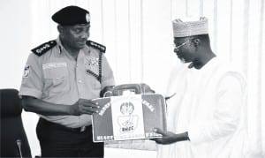 INEC chairman Prof. Attahiru Jega (right), presenting  INEC bag to the Acting IG, Mr Solomon Arase, during his first visit to INEC headquarters in Abuja, recently.