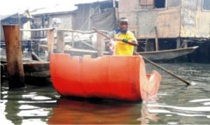 A pupil paddling himself in an improvised canoe to School at Makoko Community in Lagos State, recently.