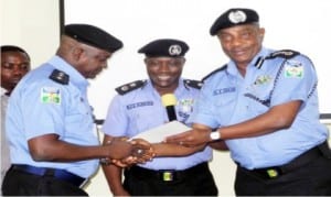 I-G Solomon Arase (right), presenting commendation letter to Police Public Relations Officer for Ogun State, Dsp Olumuyiwa Adejobi, during a workshop for Police Public Relations Officers in Abuja last Monday