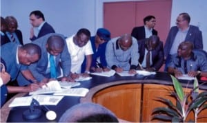 Gov. Nyesom Wike (extreme right) watch representatives of 7 companies sign MoU with the state government and RCC Nigeria Limited in the emergency repair of KM0-15 East/West Road phase 3  at Indoroma conference hall, Eleme.