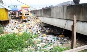 Refuse dump spilling over a bridge at Tombia junction in Yenagoa on Tuesday.                      Photo: NAN