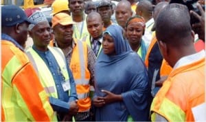 Permanent Secretary, Federal Ministry of Aviation, Hajia Binta Bello (middle), speaking with the rescue team at the scene of Wednesday's crashed helicopter, as two more bodies were recovered at Oworoshoki in Lagos, yesterday 