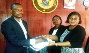 Executive-Director, Centre for Citizens with Disabilities, Mr David Anyaele (left), presenting a research report on access to justice and persons with disabilities to representative of the Chief Judge, Ikeja High Court, Mrs Funmi Ajayi (right) in Lagos on Friday. With them is the Deputy Registrar, Mrs Judith Momodu.