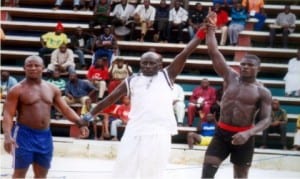 A referee (middle), declaring a winner in a traditional wrestling duel in a past National Sports Festival