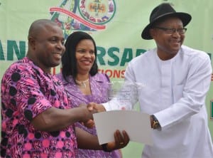 Representative of the Permanent Secretary, Federal Ministry of Culture, Tourism and National Orientation, Mr George Ufot (right), presenting an award to the Director, Akwa Ibom State Council for Arts and Culture, Mr Inyang Inyang-Udo, during  the closing ceremony of the National Council for Arts and Culture’s 40th anniversary  celebration in Abuja on Tuesday. With them is the Director-General of NCAC, Mrs Dayo Keshi.