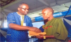 Head of Service,  Rivers State,  Barrister Rufus Godwins (left), presenting a Merit Award to a civil servant in the office of the  Head of Service,  Mr. George Geoffrey, during  Civil Service Week celebration in Port Harcourt, yesterday         Photo: Chris Monyanaga