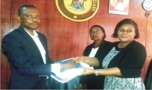 Executive Director, Centre for Citizens with Disabilities, Mr David Anyaele (left), presenting a research report on Access to Justice and Persons wth Disabilities to Representative of the Chief Judge, Ikeja High Court, Mrs Funmi Ajayi (right), in Lagos  recently. With them is the Deputy Registrar, Mrs Judith Momodu.