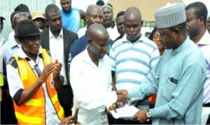 Leader of the Presidential Committee on Flood Relief and Rehabilitation, Mr Umar Gulani (right), handing over to the contractor, Mr Kopshak Gomwalk, the contractual documents for the hostels project, during the ground breaking ceremony and handing over of the site in Shendam LGA of Plateau State, recently. With him is the Executive Secretary, Plateau State Emergency Management Agency, Mr Al-Hassan Barde (left).