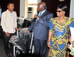 Permanent Secretary,  Ministry of Women Affairs and Social Development,   Dr Ezekiel Oyemomi (left), presenting a wheel chair  to the Coordinator, Congenital   Deformity Babies Foundation, Kaduna, Mr Innocent Uche, on behalf of the foundation  in Abuja, recently.  With them is the Director, Rehabilitation, Ms  Victoria Akintaro.