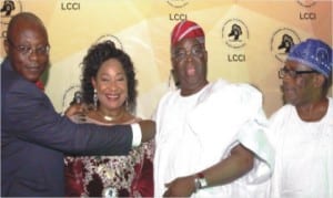 Out-going President, Lagos Chamber of Commerce and Industry (LCCI), Alhaji Remi Bello (left), decorating the incoming president of the Chamber, Dr Nike Akande (2nd right) in Lagos, yesterday. With them are her husband,Chief Adebayo Akande (2nd right) and former President of LCCI,Chief John Odeyemi.