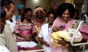 Wife of Rivers State Governor, Justice Suzzette Nyesom Wike (right), admiring the New Year baby born to Mr and Mrs Harrison at the University of Port Harcourt Teaching Hospital on New Year Day. With her is Chief Medical Director of the hospital, Prof Aaron Ojule (left).