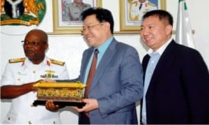 Chief of Naval Staff, Vice Admiral Ibok-ete Ibas (left), receiving a souvenir from the Chairman, Beijing Jiany Investment Group, Mr Zhang Ming (middle), during their visit to Naval headquarters in Abuja on Monday . With them is the Manager, Beijing Jiany Investment Group, Mr Li Shuo.