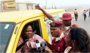 Sector Commander, Federal Road Safety Commission in Anambra State, Mr Sunday Ajayi (middle), sensitising a driver on the need to install speed limiter on his vehicle before April 1, 2016, in Awka on Tuesday.