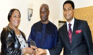 Representative of the Minister of Foreign Affairs, Mr Akinyemi Bolaji (right), presenting an award to Nigeria's former High Commissioner to the Gambia, Amb. Esther Audu, in recognition of building a robust bilateral relations between Nigeria and Gambia, during the first Edition of Diplomatic Correspondents Association of Nigeria (DICAN's) Diplomatic awards night in Abuja on Wednesday. With them is the envoy's spouse, Mr John Audu.