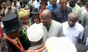 Rivers State Governor, Chief Nyesom Wike (2nd right), exchanging pleasantries with Obio/Akpor LGA traditional rulers, during the flagging off of the construction of four link roads in the area. Inset is Governor Wike driving  a grader to kick-start the roads construction.