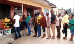 Rivers State Commissioner for Social Welfare and Rehabilitation, Hon Damiete Herbert Miller (in front), queuing for his accreditation in Ward 17 Unit 1, Oguruama in Degema, during the rerun election on Saturday in