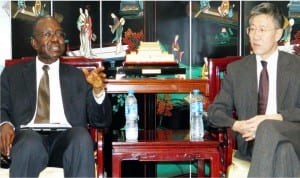 Deputy Commissioner of the Chinese Embassy, Mr Qin Jian (right), chatting with member Local Organising Committee, World Mayors Conference, Mr Sunny Enodien, during a courtesy visit to the Embassy in Abuja, recently.