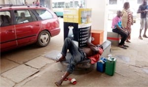 A  customer taking a nap at a filling station in Benin City after waiting for so long to  buy fuel last Sunday
