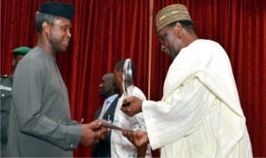 Vice-President Yemi Osinbajo (left), receiving an award on behalf of  President Muhammadu Buhari from the former Head of State,  Gen Yakubu Gowon, during  a dinner to mark International Day of Sports for Development and Peace  in Abuja on Wednesday night.