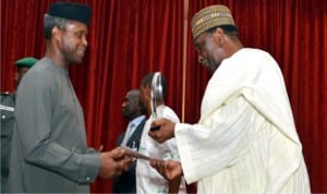 Vice-President Yemi Osinbajo (left), receiving an award on behalf of President Muhammadu Buhari from the former Head of State, Gen Yakubu Gowon, during a dinner to mark International Day of Sports for Development and Peace in Abuja on Wednesday night.