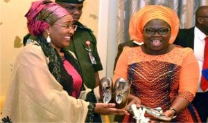 Wife of the  President, Mrs Aisha  Buhari (left) receiving Aba made-in-Nigeria products  from  wife of the Governor of Abia State,  Mrs Nkechi  Ikpeazu,  during a courtesy call on the wife of the president by Abia State women in Abuja on Wednesday.