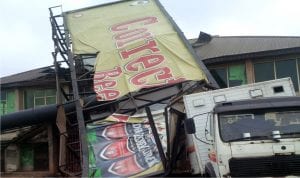 Billboard that fell and destroyed a building and truck, during a  recent rain storm in Benin City.